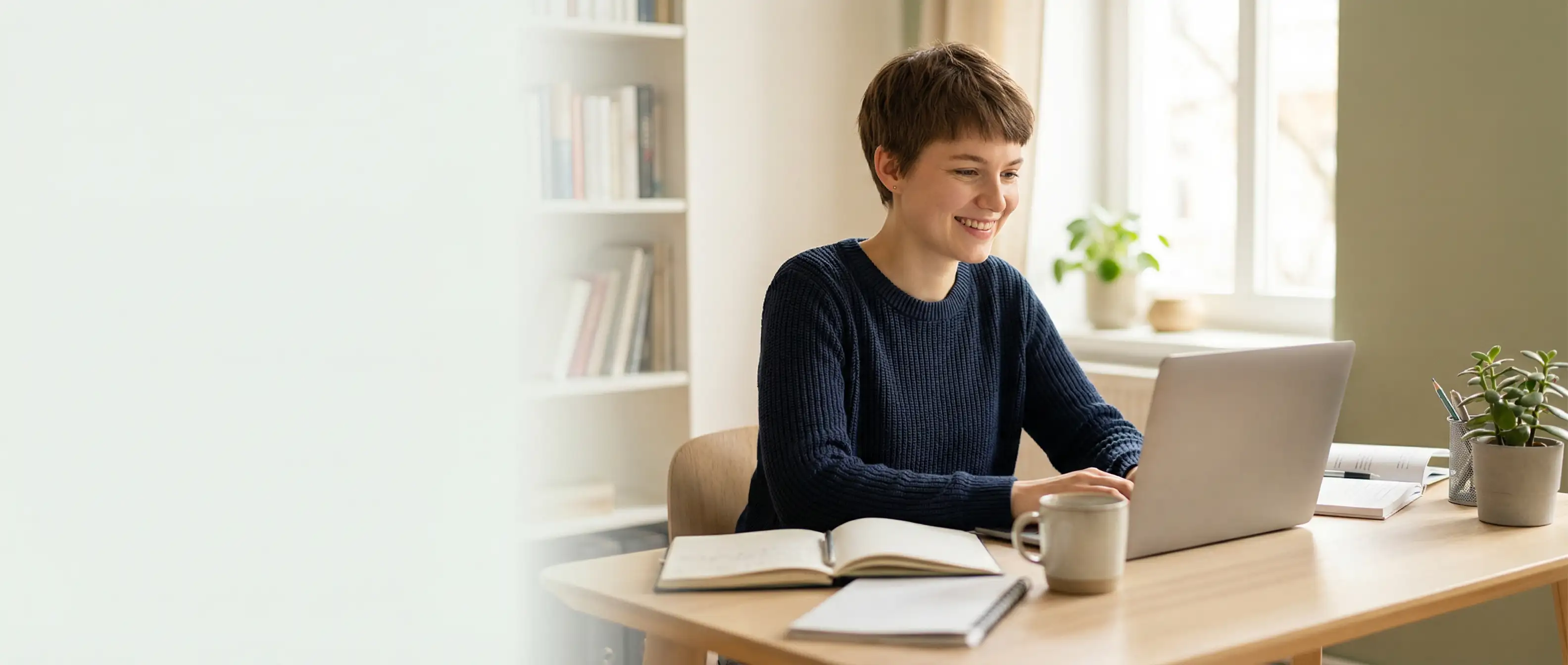Studentin arbeitet am Laptop in hellem Arbeitsbereich